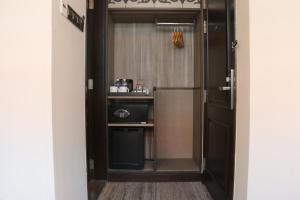 eine Tür, die in eine Küche mit einem Kühlschrank führt in der Unterkunft Aqueen Prestige Hotel Lavender in Singapur