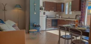 une cuisine avec une table et des chaises dans une pièce dans l'établissement Joli appartement en Corse avec piscine, à Belgodère 5 autres photos