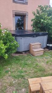 - un bain à remous installé dans une cour avec une table dans l'établissement Appartement avec SPA et jardin, à La Chapelle
