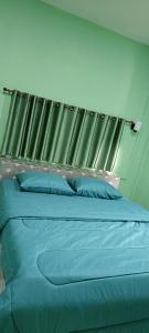 Una cama con sábanas azules y almohadas azules en un dormitorio. en วรรณรีสอร์ทwanresort, en Seka