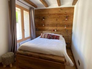a bedroom with a bed with a wooden wall at Chalet de charme 190m2, La Lauzière, ski à pieds in Peisey-Nancroix