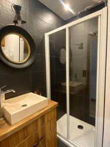 a bathroom with a shower and a sink and a mirror at Chalet de charme 190m2, La Lauzière, ski à pieds in Peisey-Nancroix