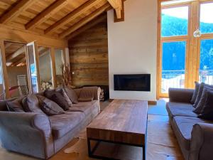 a living room with a couch and a coffee table at Chalet de charme 190m2, La Lauzière, ski à pieds in Peisey-Nancroix