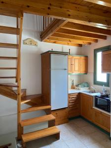 una cocina con una escalera que conduce a una nevera en Pinelopi Holiday House, en Melínta