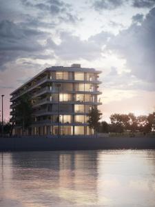 a large building next to a body of water at Luxe-appartement aan de Schelde in Antwerp