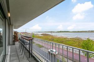 a balcony with a view of a beach and a car at Luxe-appartement aan de Schelde in Antwerp