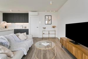 a living room with a couch and a tv at Luxe-appartement aan de Schelde in Antwerp