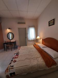 a bedroom with a large bed and a table at Seri Bulan Condo in Port Dickson