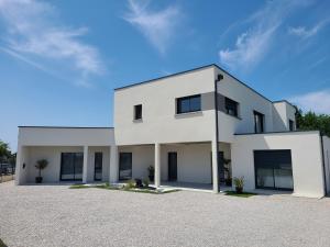 a white house with a lot of windows at L'escale Romanesque in Ozeville