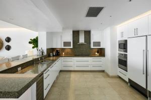 a kitchen with white cabinets and granite counter tops at Portico 3 by Blue Sky Luxury in Saint James