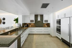 Una cocina con gabinetes blancos y encimeras de granito. en Portico 3 by Blue Sky Luxury, en Saint James