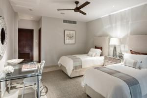 a hotel room with two beds and a glass table at Portico 3 by Blue Sky Luxury in Saint James