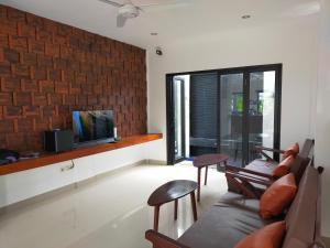 a living room with a couch and chairs and a tv at Villa Limun in Ujung