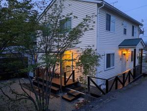 Casa blanca con porche con terraza en ホリデーハウス慈野(ジノ), en Takayama