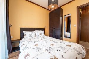 a bedroom with a large bed with a white comforter at Peaceful Bansko Hideout in Bansko