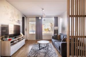 a living room with a couch and a tv at Relaxing apartment by sea + Sauna + free Parking in Helsinki