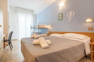 een slaapkamer met 2 bedden en een stapelbed bij Hotel Santiago in Rimini