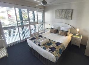 - une chambre avec un grand lit et des oreillers dans l'établissement The Norfolks on Moffat Beach, à Caloundra