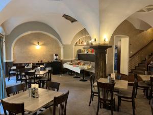 a restaurant with tables and chairs and a staircase at Hotel U Dvou medvídků in Chomutov