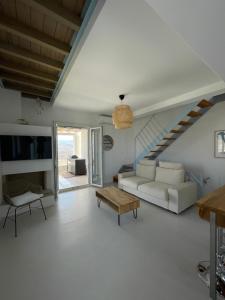 a living room with a couch and a table at VIlla Gorgona, maison cycladique in Gavrion