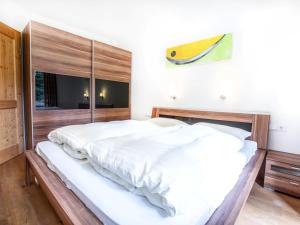 Un dormitorio con una gran cama blanca y una ventana en Chalet Hochkrimml with sauna on the ski slope, en Nothdorf