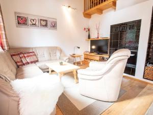 a living room with a couch and a tv at Chalet Hochkrimml with sauna on the ski slope in Nothdorf