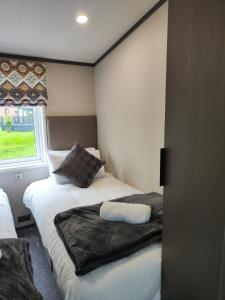 a bedroom with two beds and a window at JJs Lodge Oaktree in Thornton