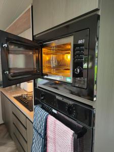 a kitchen with an oven with two microwaves at JJs Lodge Oaktree in Thornton
