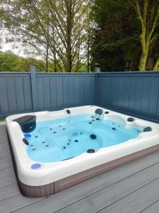 a jacuzzi tub sitting on a deck at JJs Lodge Oaktree in Thornton