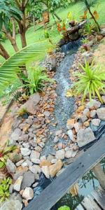 a garden with rocks and plants and a wooden bench at Najjamee Bungalows in Ko Yao Noi