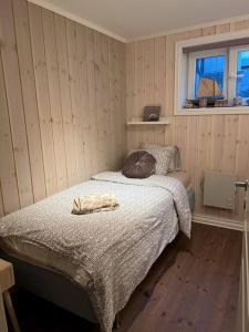 1 dormitorio con cama y ventana en Tjodalyng - ved Viksfjord - sokkelleilighet en Larvik