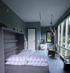 um quarto com uma cama grande e uma janela grande em Tjodalyng - ved Viksfjord - sokkelleilighet em Larvik