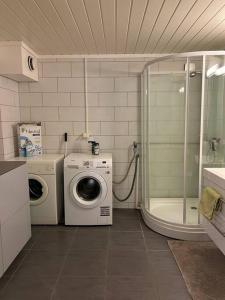 ein Badezimmer mit einer Waschmaschine und einer Waschmaschine in der Unterkunft Tjodalyng - ved Viksfjord - sokkelleilighet in Larvik