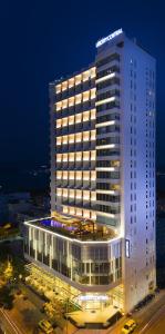 فندق ليبرتي سينترال نها ترانج في نها ترانغ: مبنى مضاء وامامه موقف سيارات