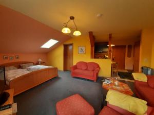 a bedroom with a bed and a couch and chairs at Apartments Josef Seitz in Bayerisch Eisenstein