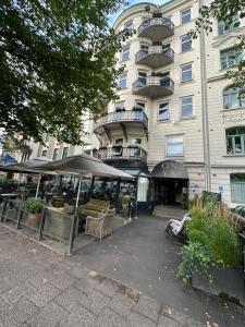 - un bâtiment avec un parasol et des chaises en face dans l'établissement Hotell Onyxen, à Göteborg