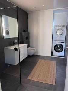 a bathroom with a washing machine and a washer and dryer at Top Floor Apartment Årossanden 5 A in Kristiansand