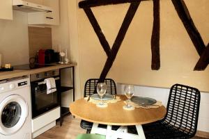 a kitchen with a table with two wine glasses at La Bohè’m night in Villeneuve-la-Guyard