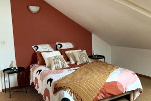 Un dormitorio con una cama con almohadas. en La Bohè’m night, en Villeneuve-la-Guyard