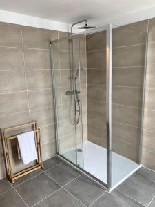 a shower stall with a glass door in a bathroom at La Bohè’m night in Villeneuve-la-Guyard