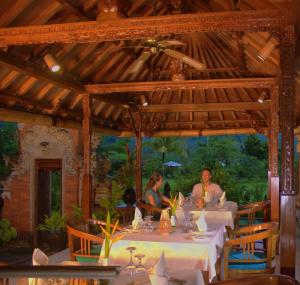 a group of people sitting at a table in a restaurant at Puri Bagus Manggis in Candidasa