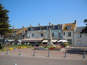 a park with a bench in front of some buildings at Appartement refait à neuf, 4 pers à Courseulles in Courseulles-sur-Mer