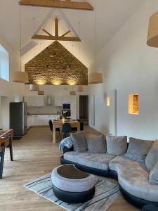 sala de estar con sofá y cocina en La Villa du Pressoir, magnifique longère Bretonne, en Belz