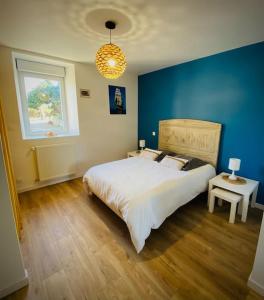 1 dormitorio con 1 cama grande y pared azul en La Villa du Pressoir, magnifique longère Bretonne, en Belz