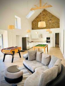 een woonkamer met een bank en een tafel bij La Villa du Pressoir, magnifique longère Bretonne in Belz