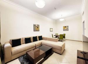 un soggiorno con divano e tavolo di RH - Spacious & bright 01BR, Near mall of Emirates a Dubai