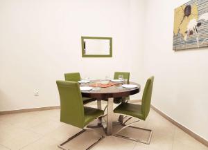 a dining room table with four green chairs at RH - Spacious & bright 01BR, Near mall of Emirates in Dubai