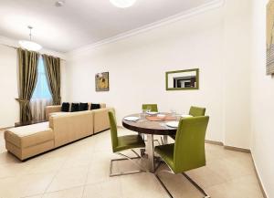a dining room with a table and green chairs at RH - Spacious & bright 01BR, Near mall of Emirates in Dubai