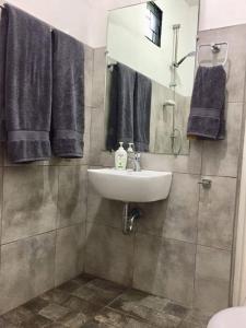 La salle de bains est pourvue d'un lavabo, d'un miroir et de serviettes. dans l'établissement A Unique and Cozy WholeHouse in Babak Samal Island, à Babak