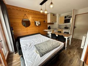 una camera con letto e parete in legno di Chaleureux logement centre Valmeinier 1800 avec Piscine -Vue Montagne - 6 personnes a Valmeinier